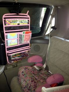 the interior of a car with pink and black items on it's back seat