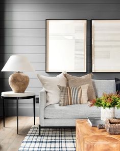 a living room filled with furniture and two framed pictures on the wall above it's coffee table