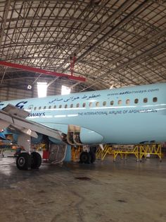 an airplane is parked in a large hangar