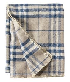 a blue and white plaid blanket folded on top of a bed