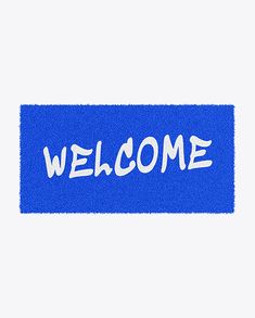 a blue welcome mat with the word welcome written on it in white ink, against a gray background