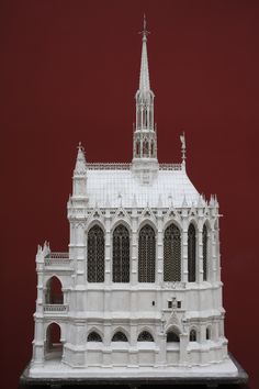 a white model of a building with a red background