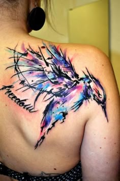 the back of a woman's shoulder with an abstract tattoo design on her upper arm