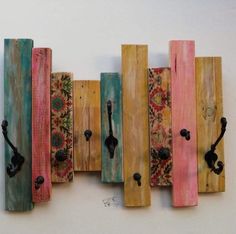 several wooden pieces with different colors and designs on them are hanging on the wall in front of a white wall