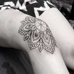 a woman's leg with a tattoo design on the lower part of her thigh