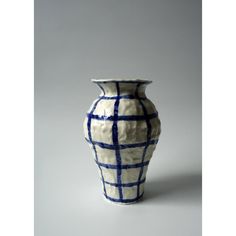 a white and blue vase sitting on top of a table