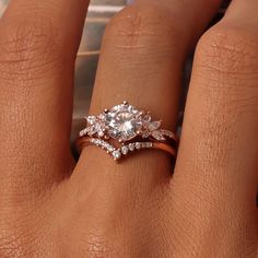 a woman's hand with an engagement ring and diamond wedding band on it,