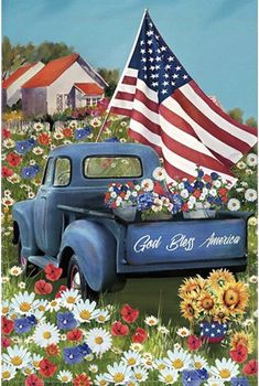 an old blue truck in a field full of flowers with the american flag on it