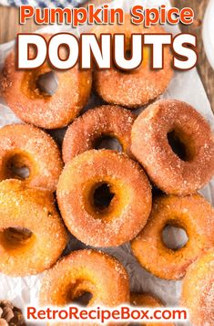 a pile of doughnuts sitting on top of a piece of wax paper with the words pumpkin spice donuts