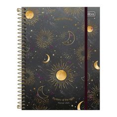 a spiral bound notebook with gold stars and moon designs on it, in front of a black background