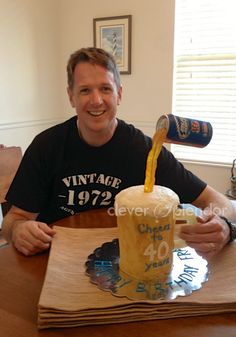 a man sitting at a table with a glass of beer