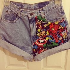 a pair of jean shorts with avengers and captain america print on the side, hanging from a hook