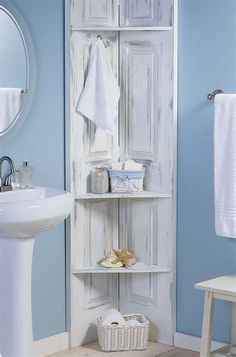 a bathroom with blue walls and white shelves in the corner, next to a sink