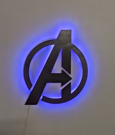 the avengers logo is lit up with blue light and has an arrow in it's center