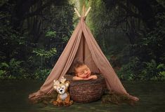 a baby sleeping in a basket with a teepee next to it and a stuffed animal