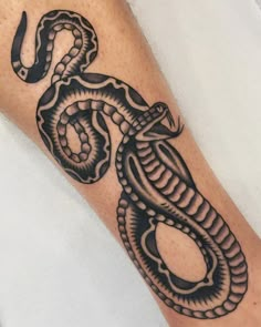 a black and white snake tattoo on the leg