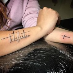 two people with tattoos on their arms that say,'telefetai '