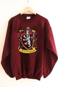 a harry potter sweatshirt hanging on a wall with the hogwarts crest in it