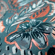 an orange and black floral design on a blue background with white, gray, and pink flowers