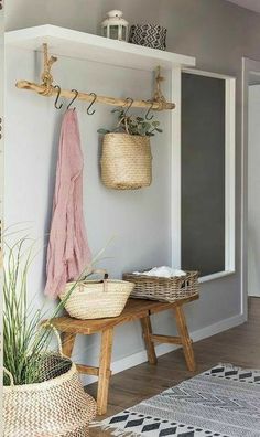 a room with some baskets hanging on the wall and a bench in front of it