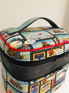 a lunch bag with cars and trucks printed on the side, sitting on a table