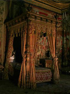 a bedroom with an elaborate canopy bed and curtains