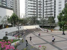 many people are walking around in an open area with flowers and plants on the ground