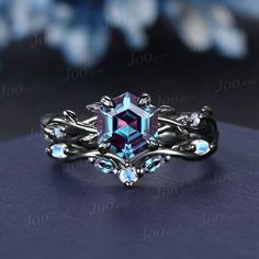 an engagement ring with blue topazte and white diamonds on it, sitting on a table