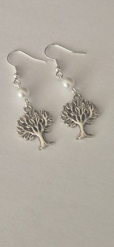 Tree of life earrings are a perfect gift for someone special.  Made with a tree of life charm in Tibetan silver. A 6 mm white pearl bead Silver plated ear wire Overall length is 4.5 cm Comes presented in an organza pouch If you would prefer a different colour bead then feel free to ask and I will try to accommodate. Tree Of Life Earrings, Organza Pouch, White Pearl, Ear Wire, A Tree, Pearl Beads, Tree Of Life, Pearl White, Beaded Earrings