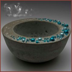 a gray bowl with blue beads in it