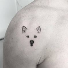 a dog tattoo on the back of a man's shoulder