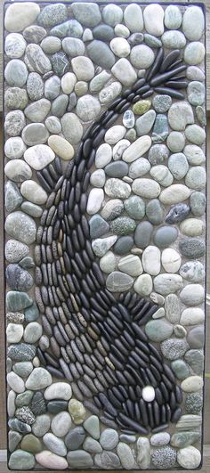 a stone wall with a yin symbol made out of rocks and pebbles on it's sides