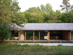 a small house in the middle of a forest with lots of trees and grass around it