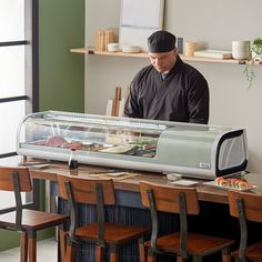 a man standing in front of a display case with food on it's sides