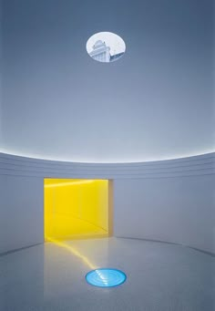 an empty room with a bright yellow door in the center and blue circles on the floor