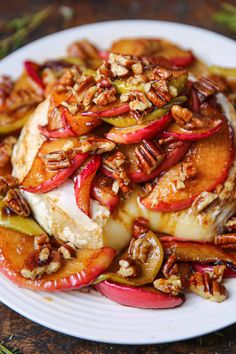 a white plate topped with chicken covered in apples and pecans