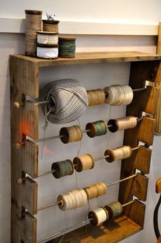 an old wooden rack with many spools of thread