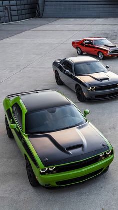 three different colored cars parked next to each other in a parking lot with concrete flooring