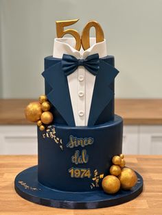 a blue and gold 50th birthday cake on a table