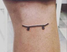 a small tattoo on the ankle of a person with a skateboard attached to it