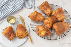 several pastries on a wire rack next to a bowl of butter