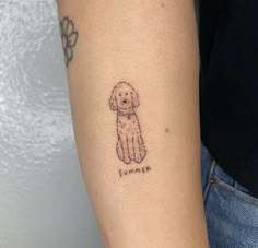 a small dog tattoo on the left arm