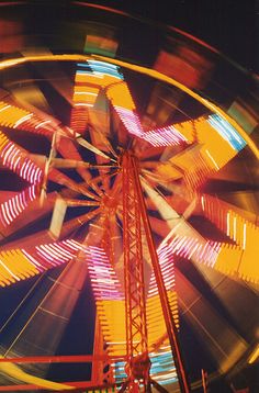 the ferris wheel is brightly lit up at night