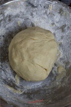 a ball of dough in a metal bowl