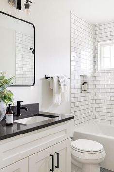 a white bathroom with black and white tile