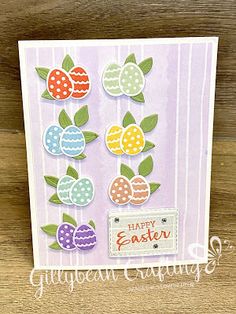 an easter card with colorful eggs and flowers on it, sitting on a wooden surface