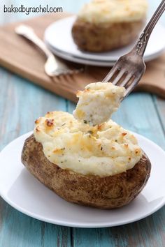 a piece of baked potato being lifted with a fork from the side on a white plate