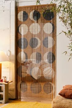 a living room with a large bamboo screen in the center and pillows on the floor