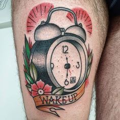 a man with a tattoo on his leg has an alarm clock and ribbon around it