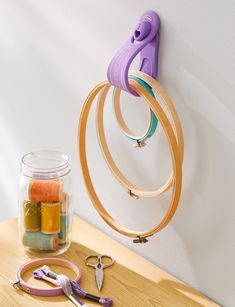 a pair of scissors hanging from a hook on a wall next to some craft supplies